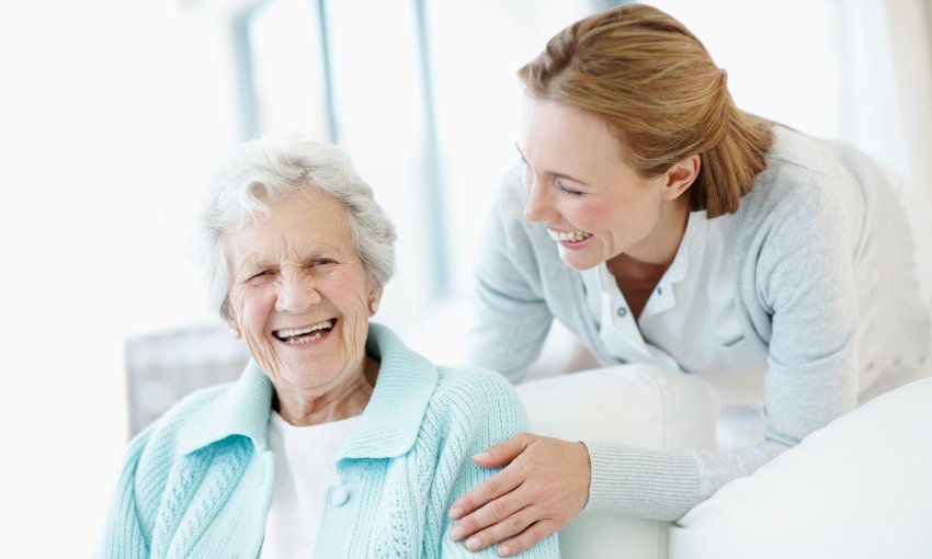 caregiver and mature woman smiling