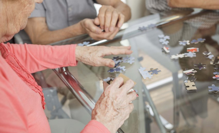 Elderly lady busy making puzzle