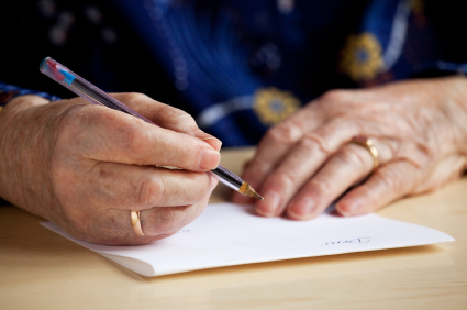 Elderly hand writing a letter