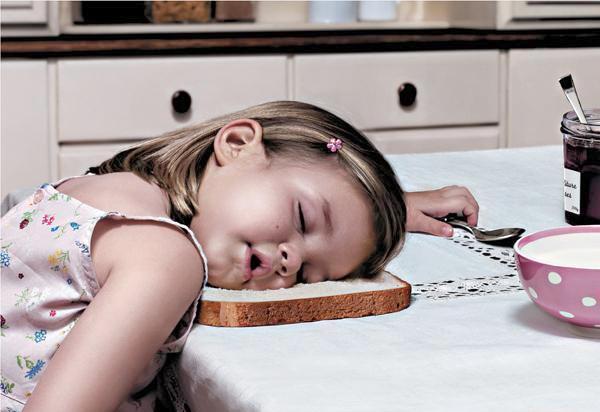 Girl sleeping over bread