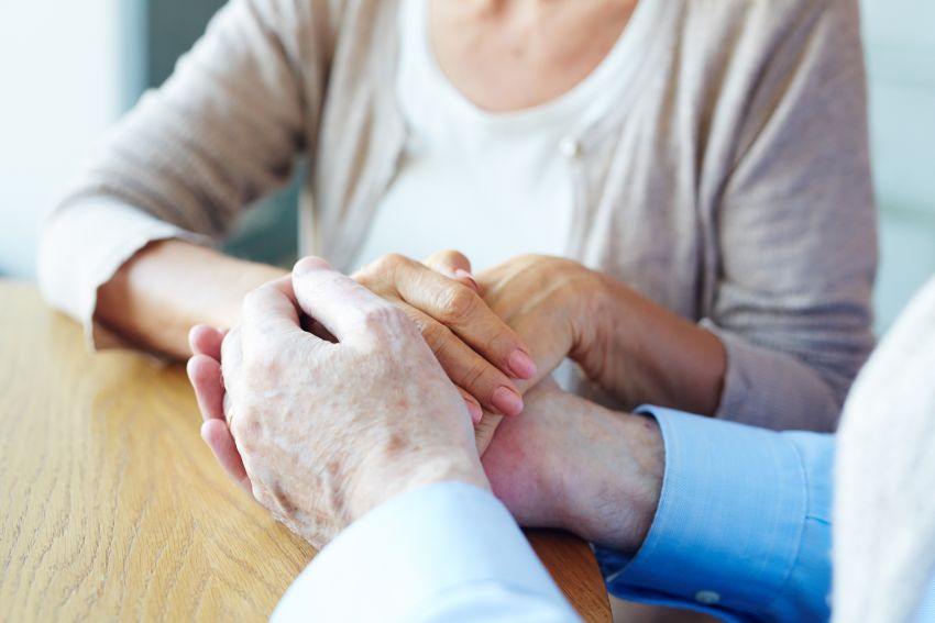 Hands of senior couple on wooden table