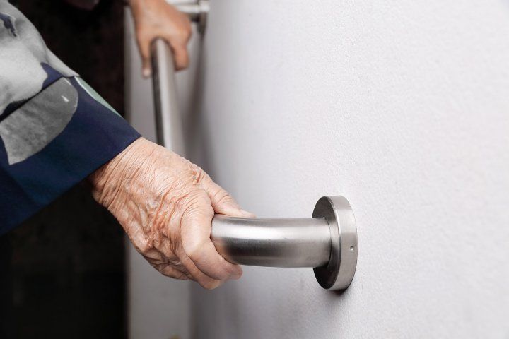 elderly at home holding safety bar 