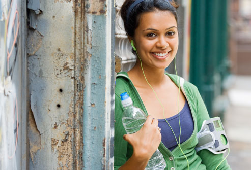 smiling indian woman holding bottled water