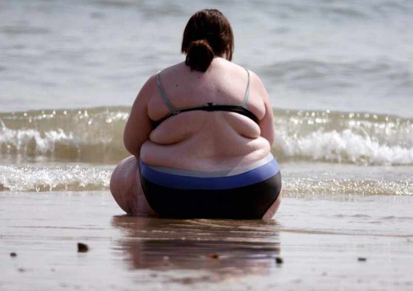 obese woman on the shoreline