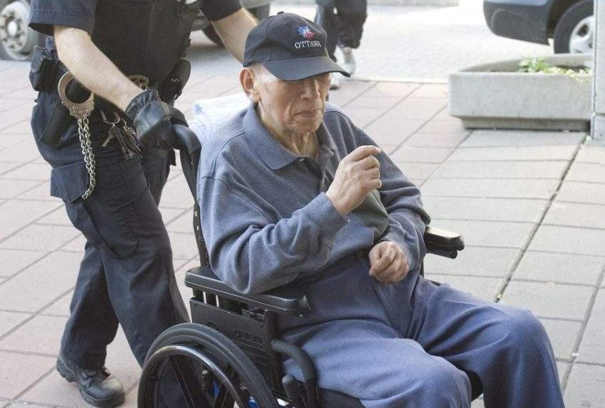 patient in wheelchair carried by policeman