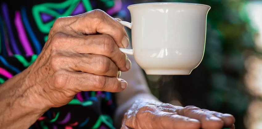 senior holding a cup of coffee